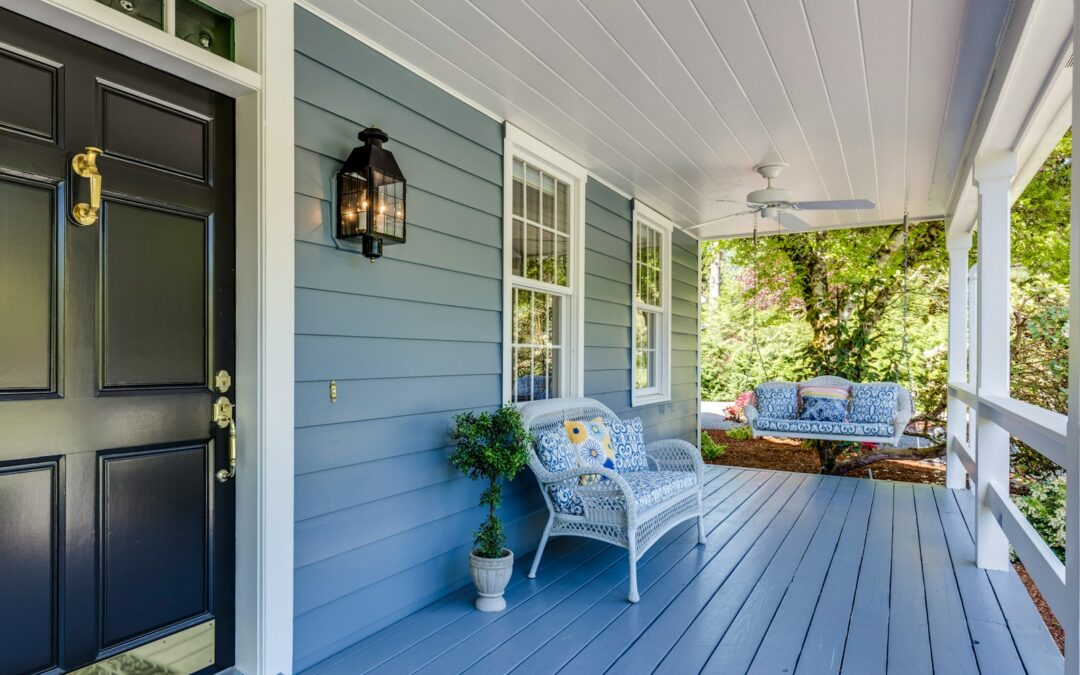 a porch with two chairs and a table on it